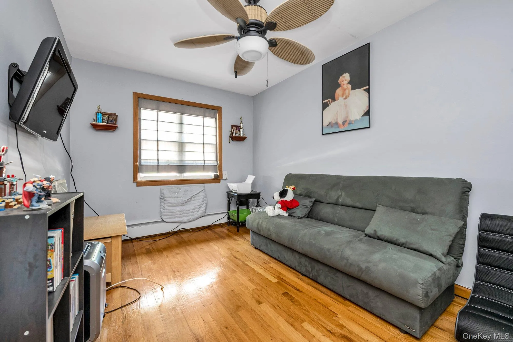 Living room with light wood-type flooring, a baseboard heating unit, and ceiling fan Living room with light wood-type flooring, a baseboard heating unit, and ceiling fan