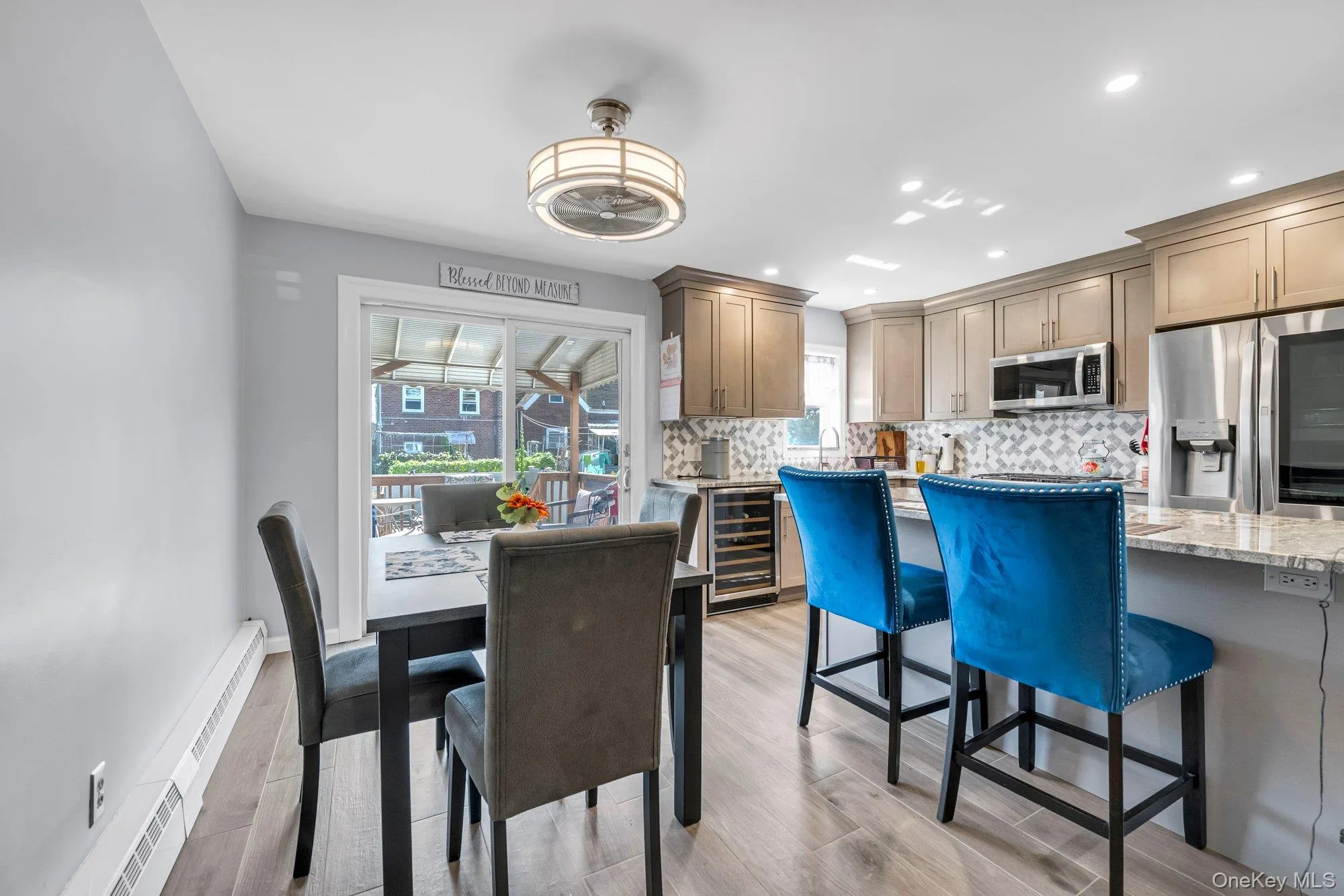 Dining area with light wood finished floors, recessed lighting, a baseboard heating unit, and wine cooler Dining area with light wood finished floors, recessed lighting, a baseboard heating unit, and wine cooler