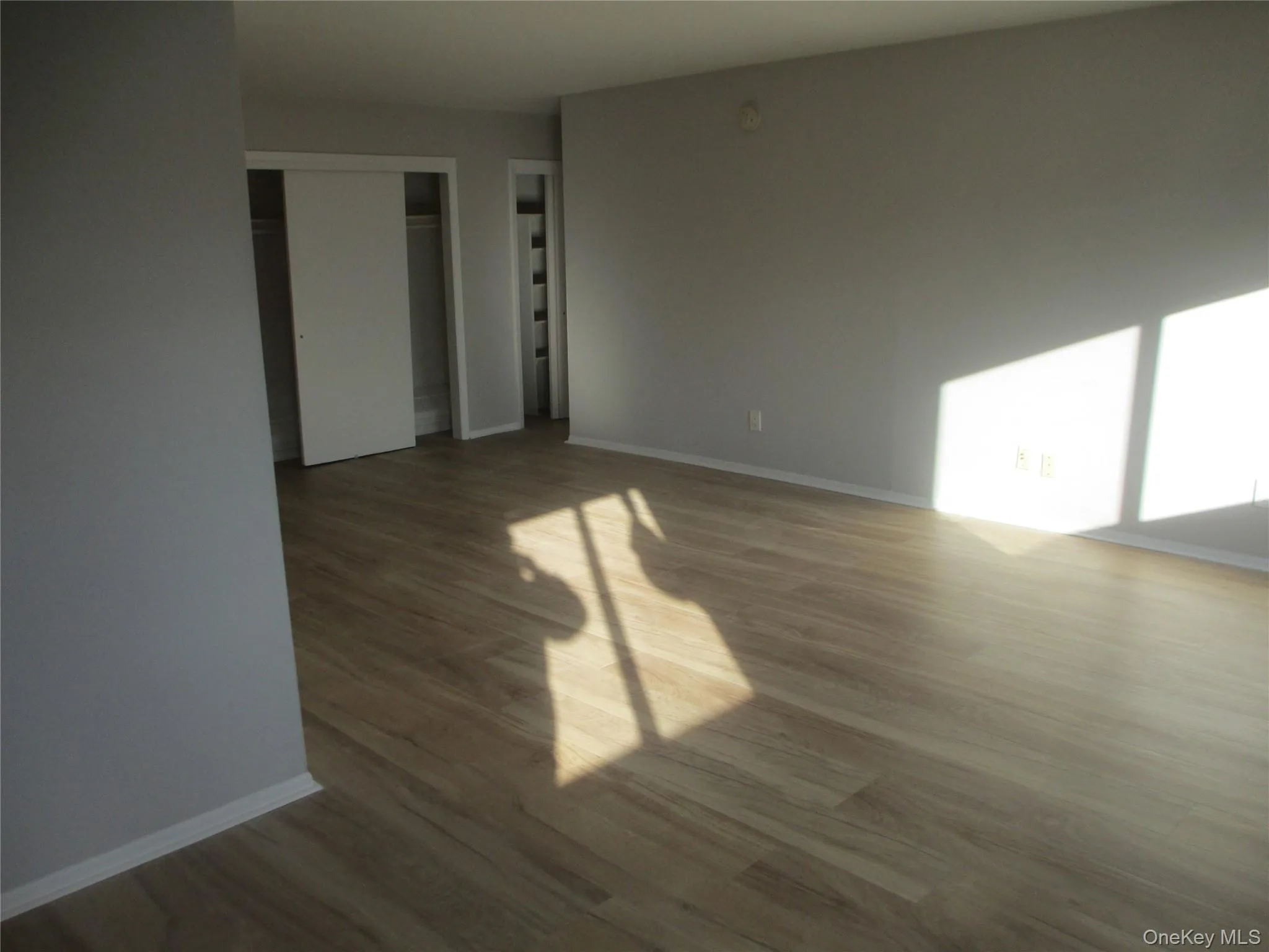 Unfurnished room with wood finished floors and baseboards Unfurnished room with wood finished floors and baseboards