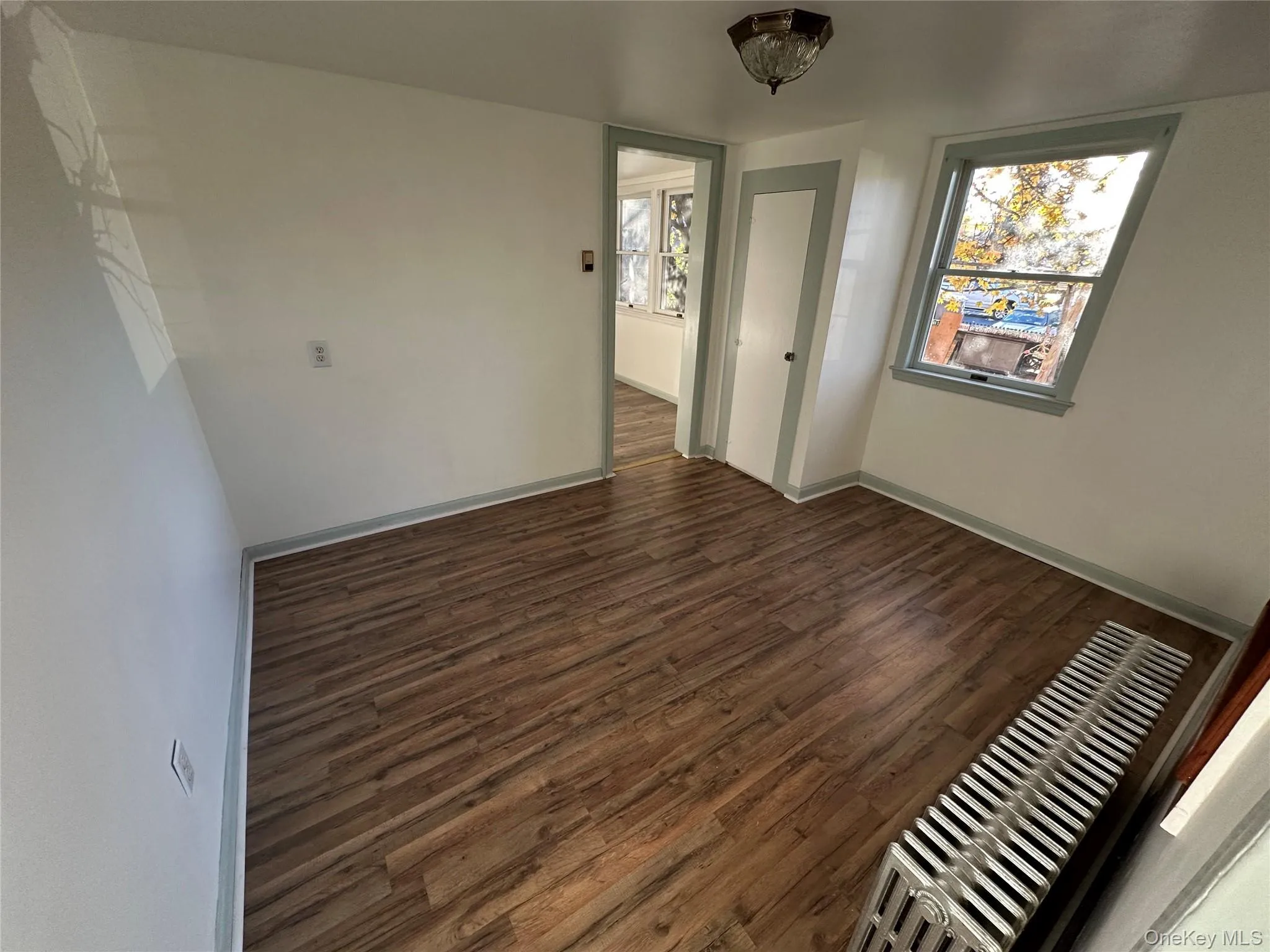 Bedroom with dark wood-type flooring and healthy amount of natural light Bedroom with dark wood-type flooring and healthy amount of natural light