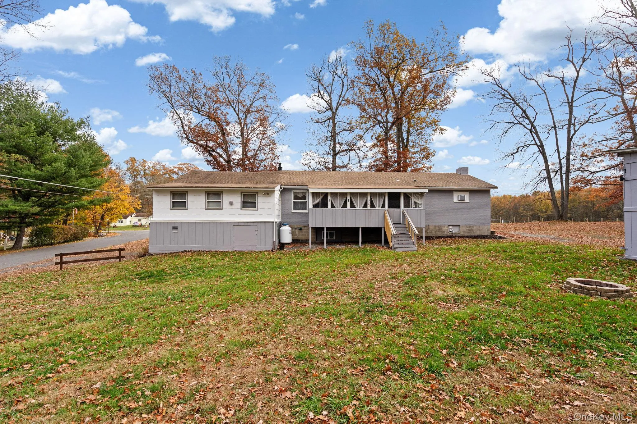 Rear view of property featuring a lawn, an outdoor fire pit, a chimney, and stairway Rear view of property featuring a lawn, an outdoor fire pit, a chimney, and stairway