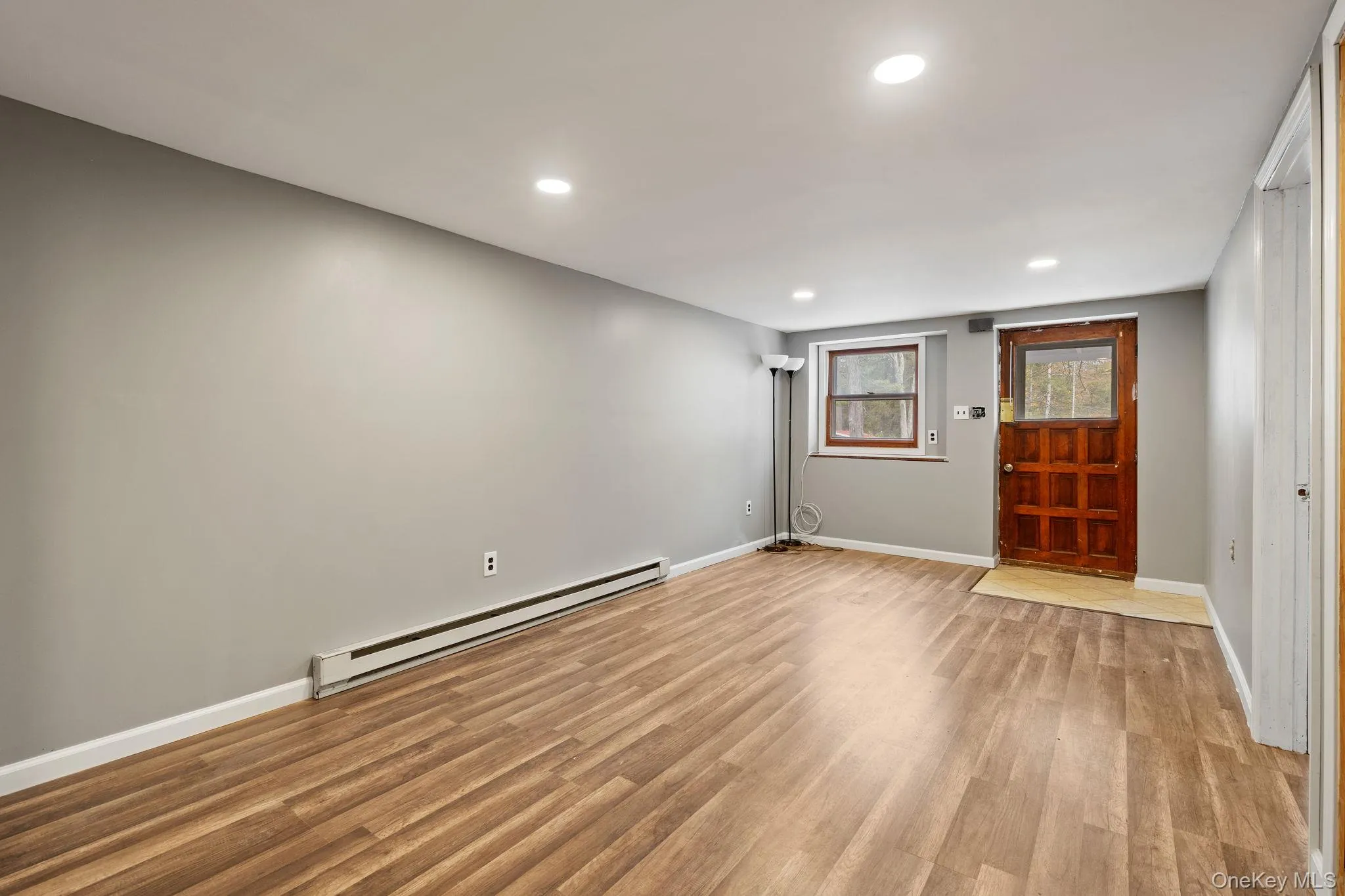 Foyer featuring a baseboard heating unit, recessed lighting, and light wood-style floors Foyer featuring a baseboard heating unit, recessed lighting, and light wood-style floors