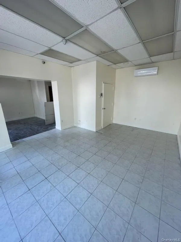 Unfurnished room featuring a drop ceiling and light tile patterned floors Unfurnished room featuring a drop ceiling and light tile patterned floors