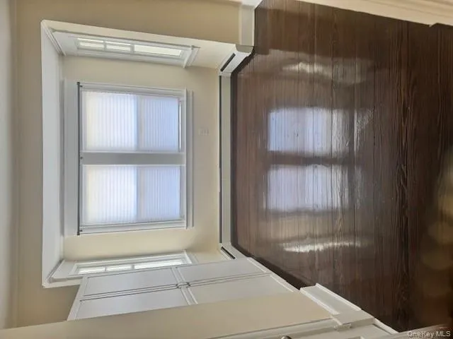 Spare room with healthy amount of natural light, dark wood finished floors, and a baseboard heating unit Spare room with healthy amount of natural light, dark wood finished floors, and a baseboard heating unit