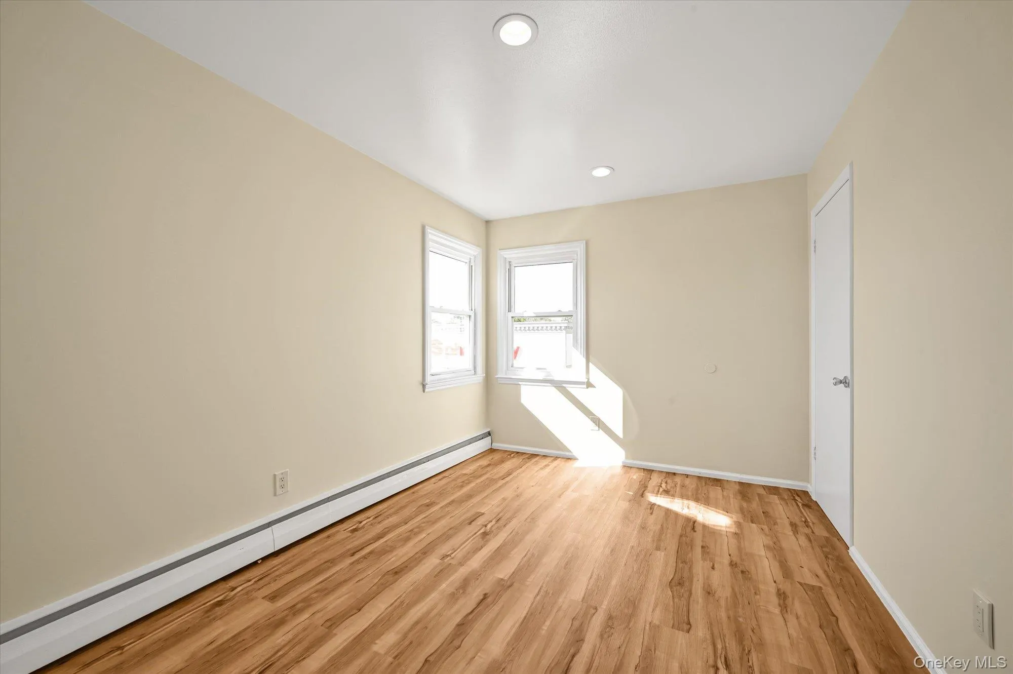 Unfurnished room featuring a baseboard heating unit, light wood-style floors, and recessed lighting Unfurnished room featuring a baseboard heating unit, light wood-style floors, and recessed lighting