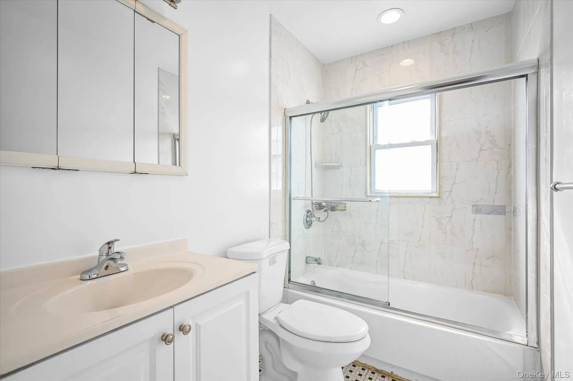 Full bathroom featuring bath / shower combo with glass door and vanity Full bathroom featuring bath / shower combo with glass door and vanity