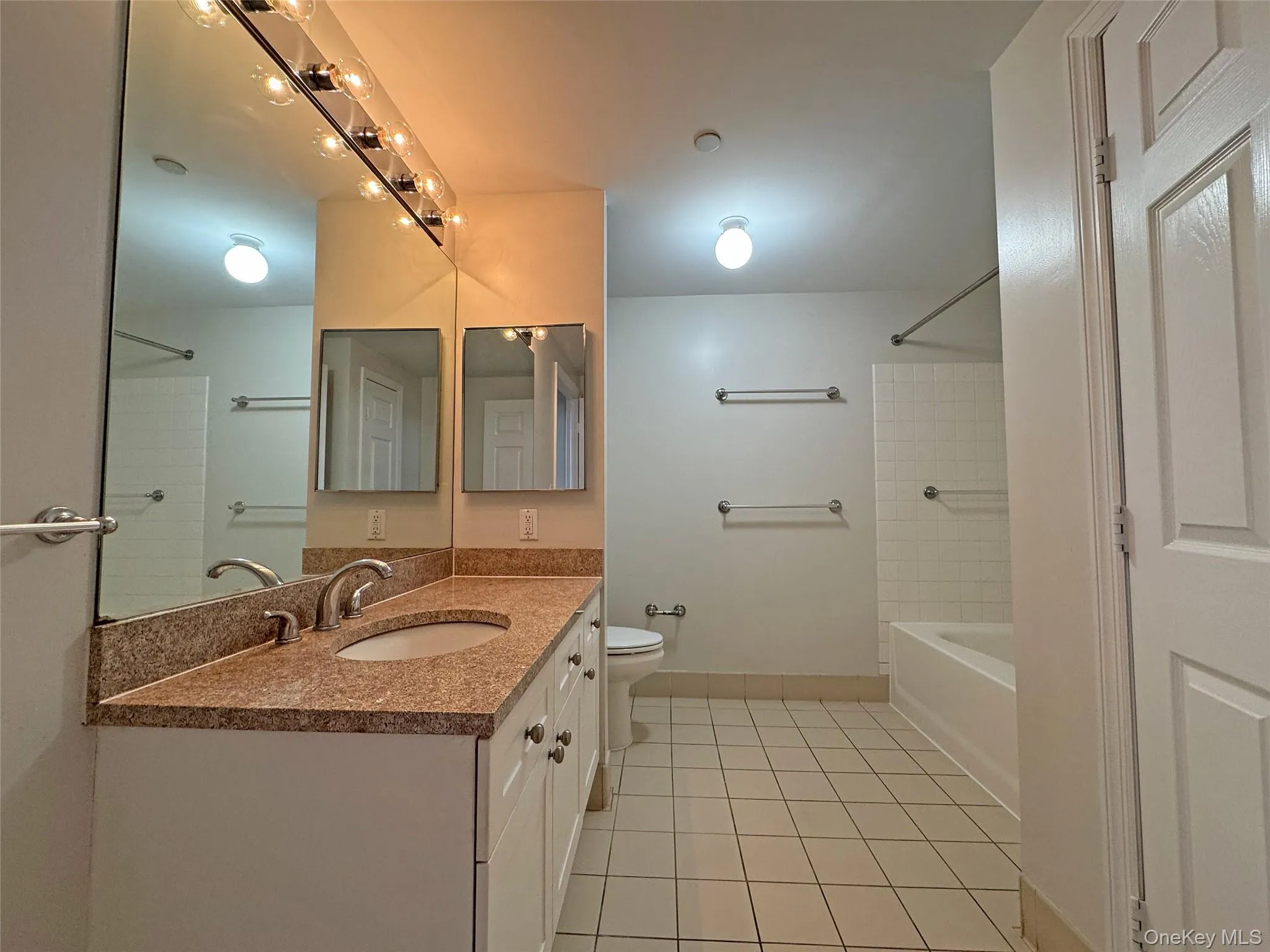 Full bath featuring vanity, light tile patterned floors, and tub / shower combination Full bath featuring vanity, light tile patterned floors, and tub / shower combination