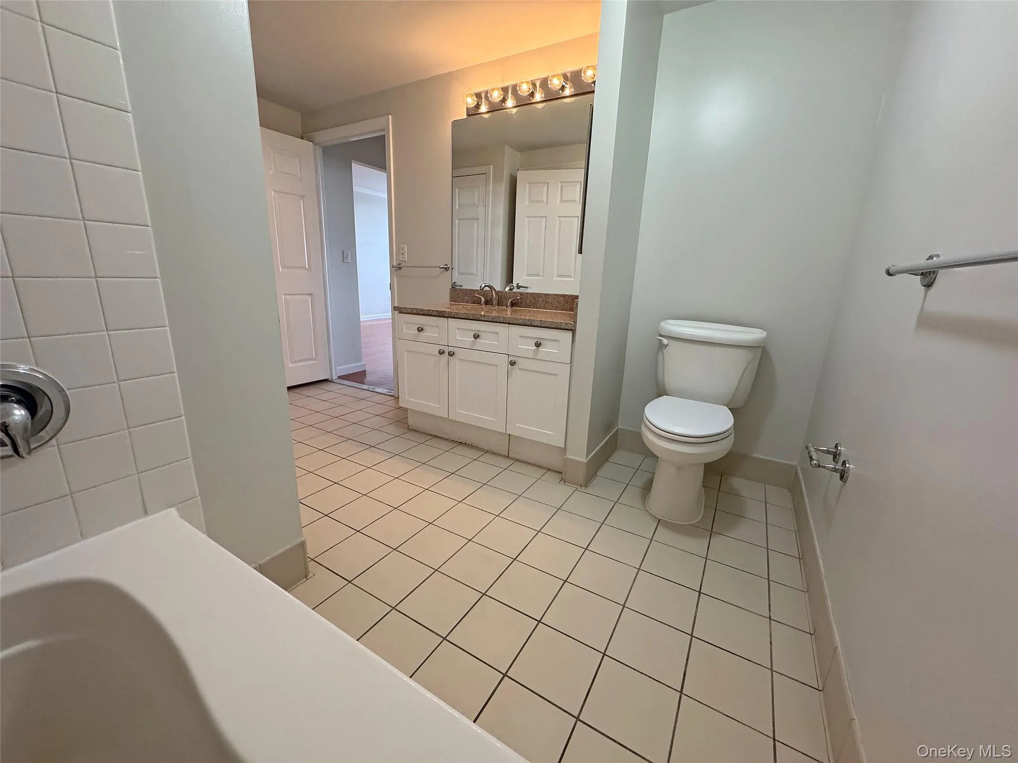 Full bathroom with vanity and light tile patterned floors Full bathroom with vanity and light tile patterned floors