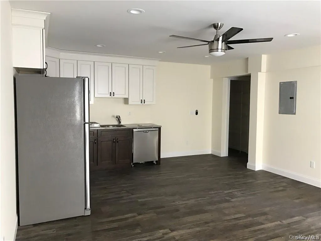 Kitchen featuring appliances with stainless steel finishes, dark wood-style floors, white cabinetry, electric panel, and recessed lighting Kitchen featuring appliances with stainless steel finishes, dark wood-style floors, white cabinetry, electric panel, and recessed lighting