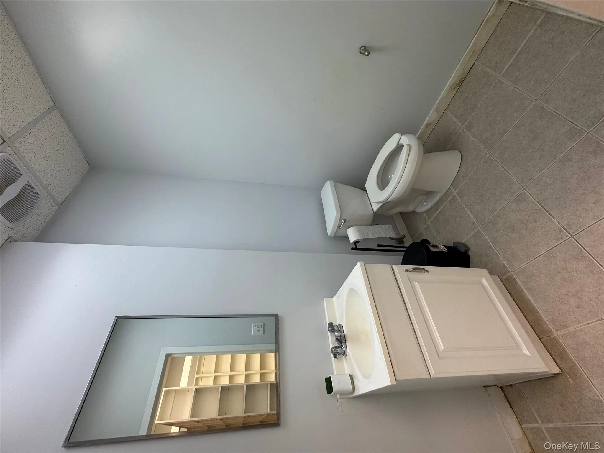 Bathroom with vanity, a paneled ceiling, and light tile patterned floors Bathroom with vanity, a paneled ceiling, and light tile patterned floors