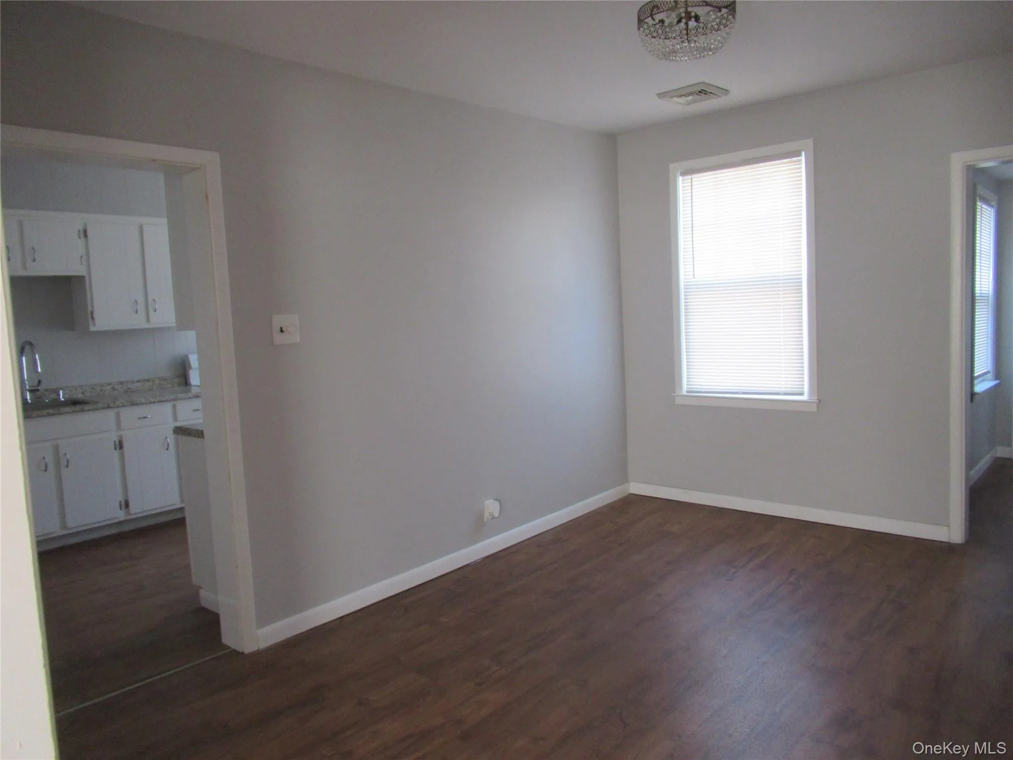 dining rm featuring baseboards and wood-style floors by kitchen dining rm featuring baseboards and wood-style floors by kitchen