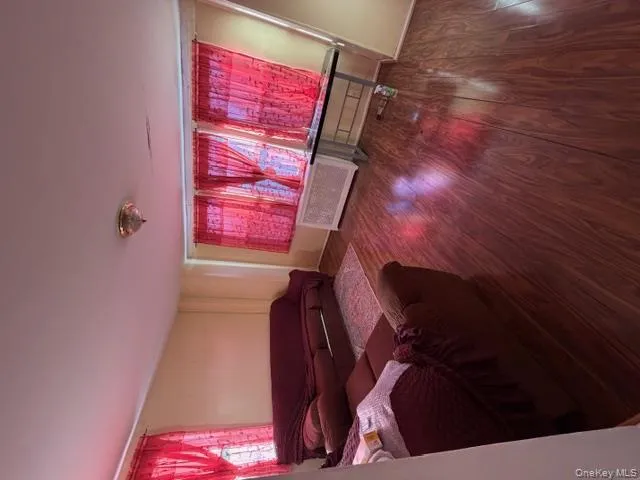 Living room featuring wood finished floors, radiator heating unit, and plenty of natural light Living room featuring wood finished floors, radiator heating unit, and plenty of natural light