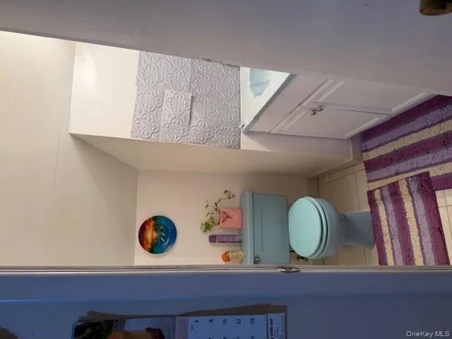 Half bath featuring vanity, light tile patterned floors, and vaulted ceiling Half bath featuring vanity, light tile patterned floors, and vaulted ceiling