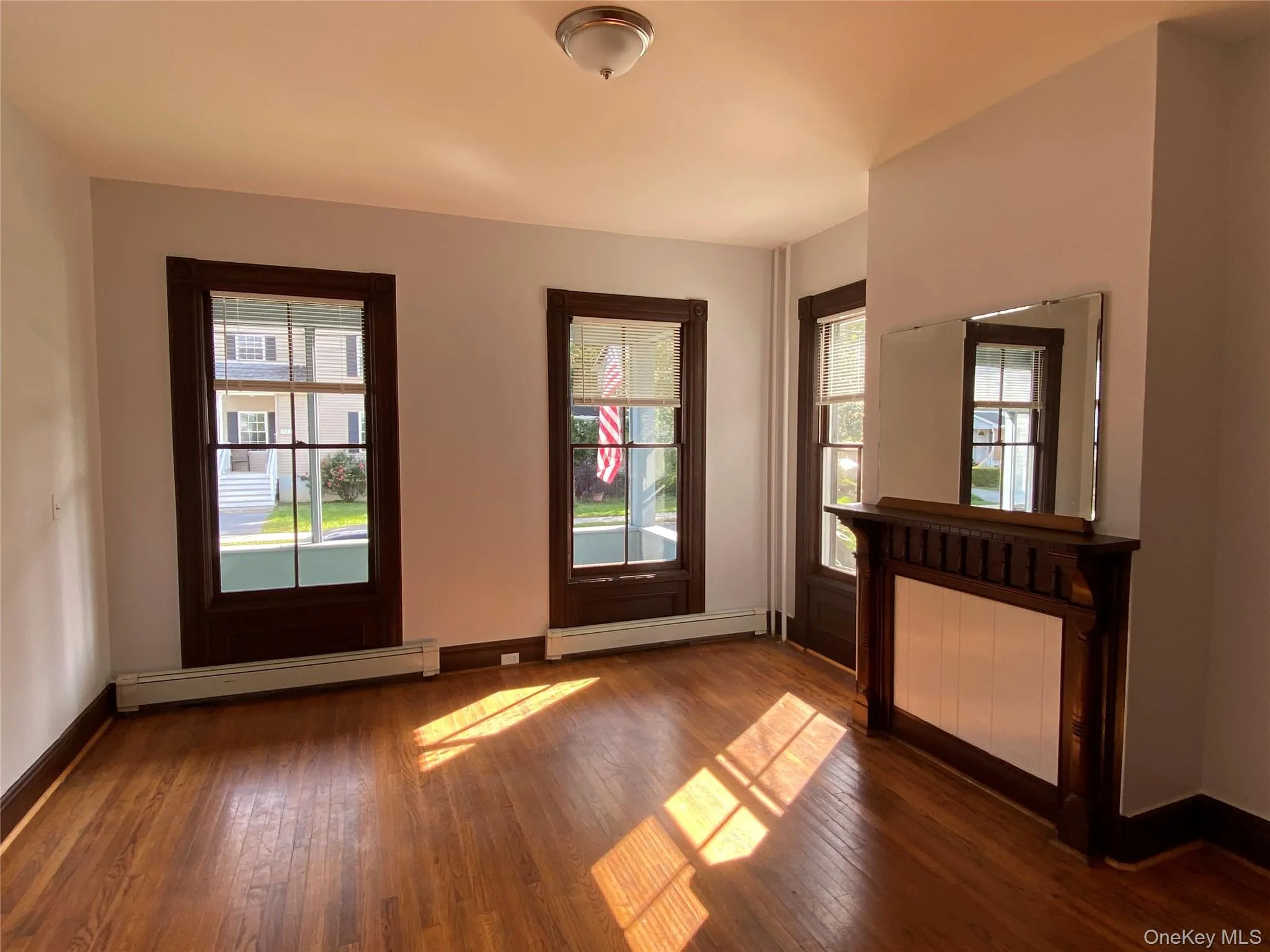 Doorway to outside featuring a baseboard radiator and hardwood / wood-style flooring Doorway to outside featuring a baseboard radiator and hardwood / wood-style flooring