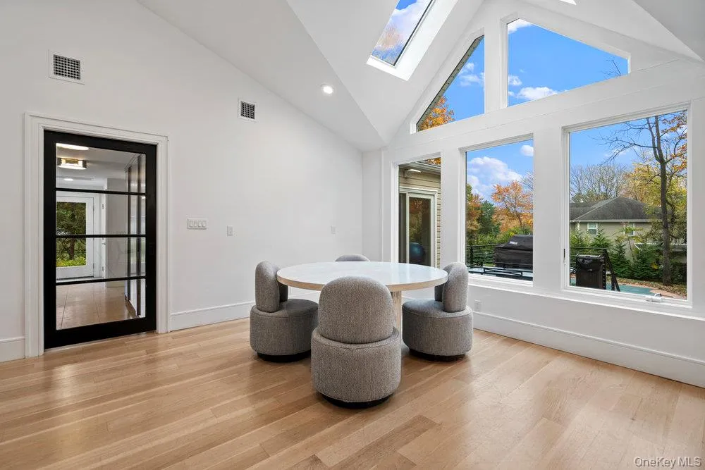 Dining area featuring high vaulted ceiling, a skylight, light wood-style flooring, and recessed lighting Dining area featuring high vaulted ceiling, a skylight, light wood-style flooring, and recessed lighting