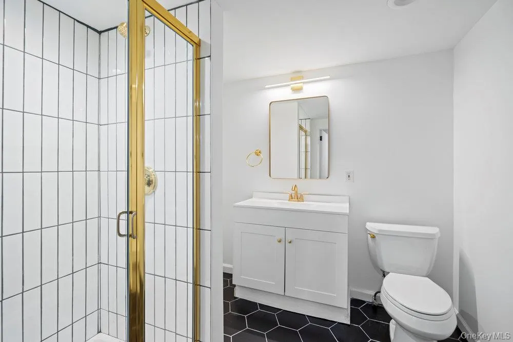Bathroom featuring dark tile patterned flooring, vanity, and a stall shower Bathroom featuring dark tile patterned flooring, vanity, and a stall shower
