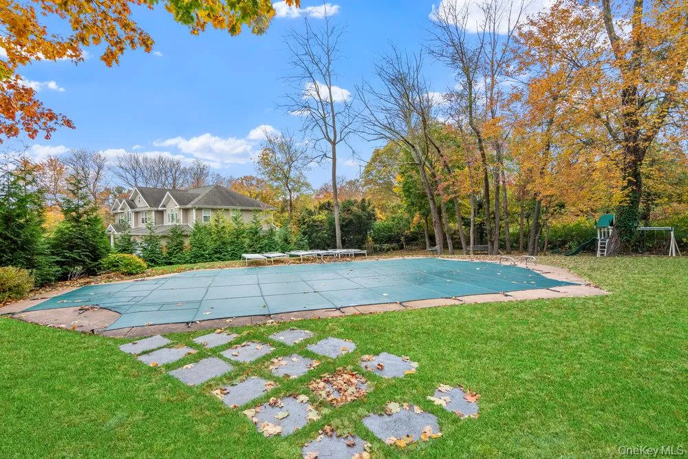 View of pool with a yard, a covered pool, a patio, and view of wooded area View of pool with a yard, a covered pool, a patio, and view of wooded area