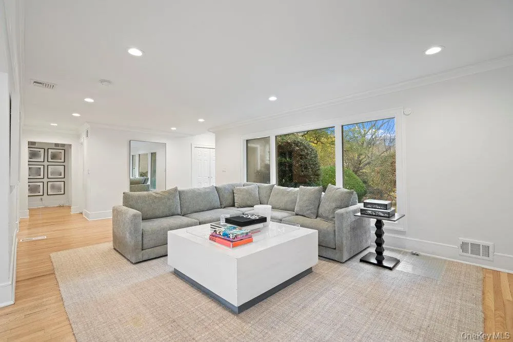 Living room with light wood-style flooring, crown molding, and recessed lighting Living room with light wood-style flooring, crown molding, and recessed lighting