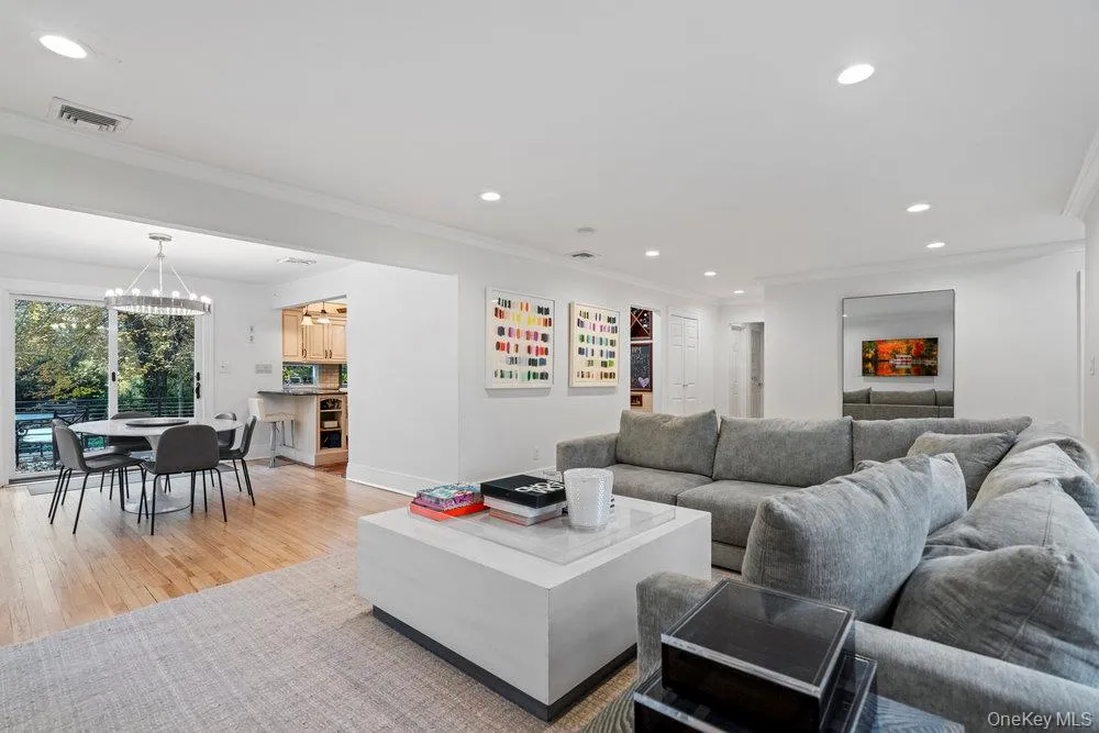 Living room featuring recessed lighting, crown molding, light wood finished floors, and a chandelier Living room featuring recessed lighting, crown molding, light wood finished floors, and a chandelier