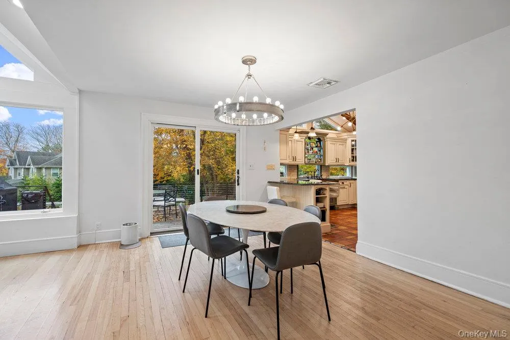 Dining space with light wood-type flooring and a chandelier Dining space with light wood-type flooring and a chandelier