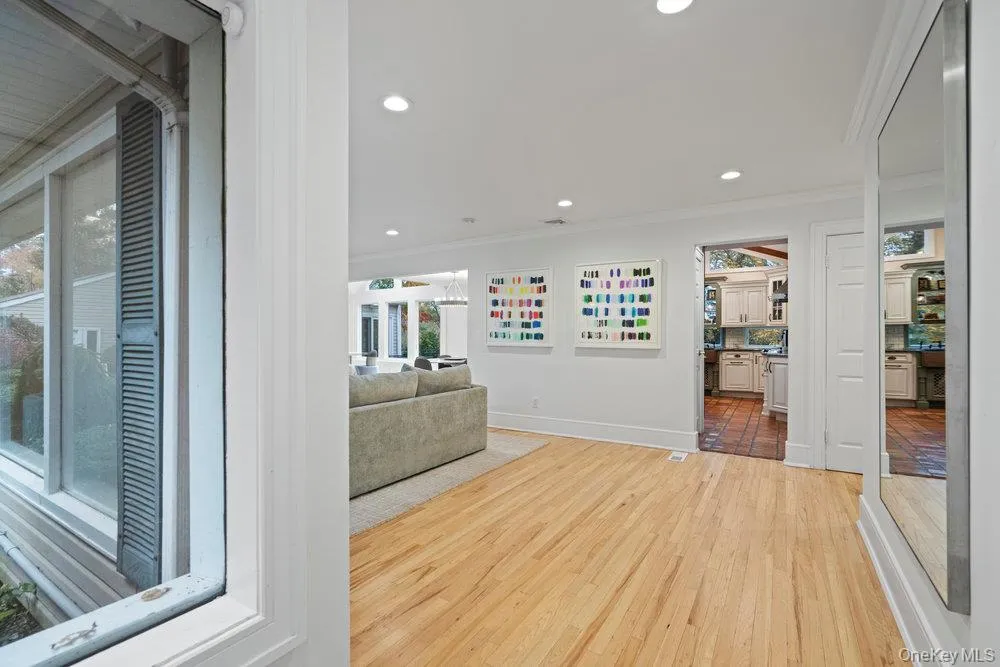 Unfurnished living room with recessed lighting, crown molding, light wood-type flooring, and healthy amount of natural light Unfurnished living room with recessed lighting, crown molding, light wood-type flooring, and healthy amount of natural light