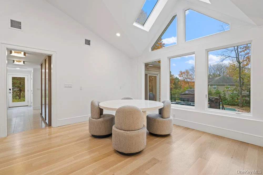 Dining area featuring high vaulted ceiling, a skylight, light wood-style flooring, and recessed lighting Dining area featuring high vaulted ceiling, a skylight, light wood-style flooring, and recessed lighting