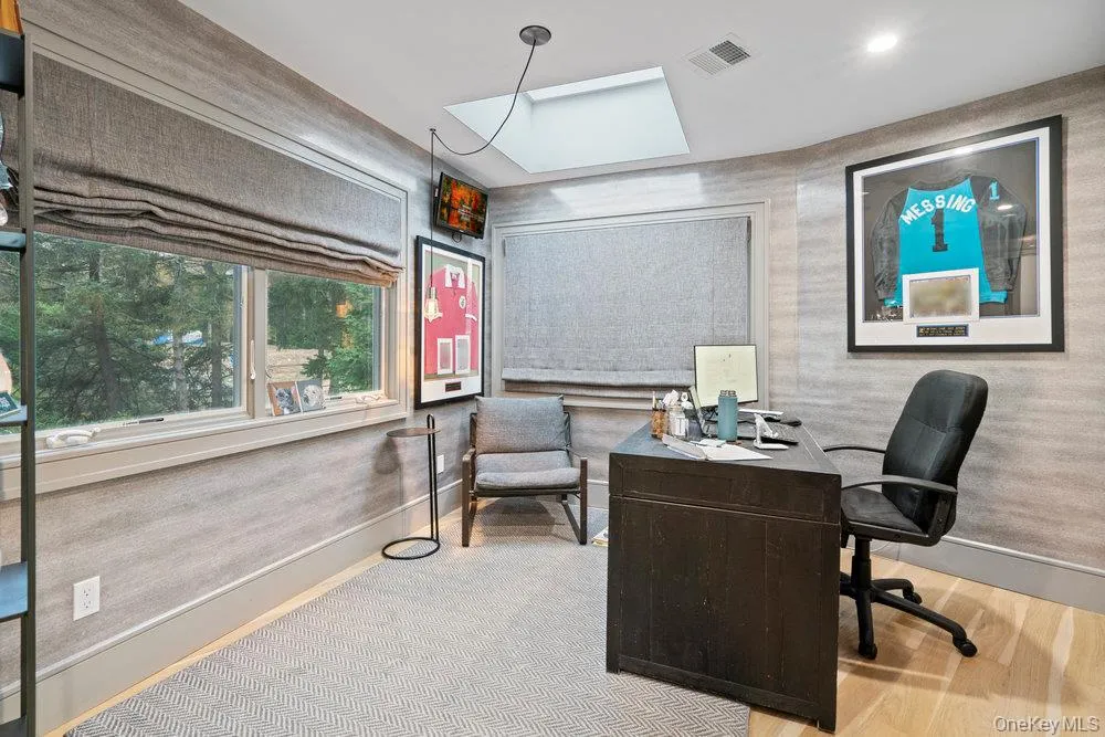 Home office with wallpapered walls and baseboards Home office with wallpapered walls and baseboards