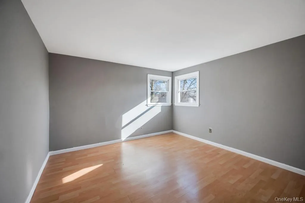 Unfurnished room with light wood-type flooring and baseboards Unfurnished room with light wood-type flooring and baseboards