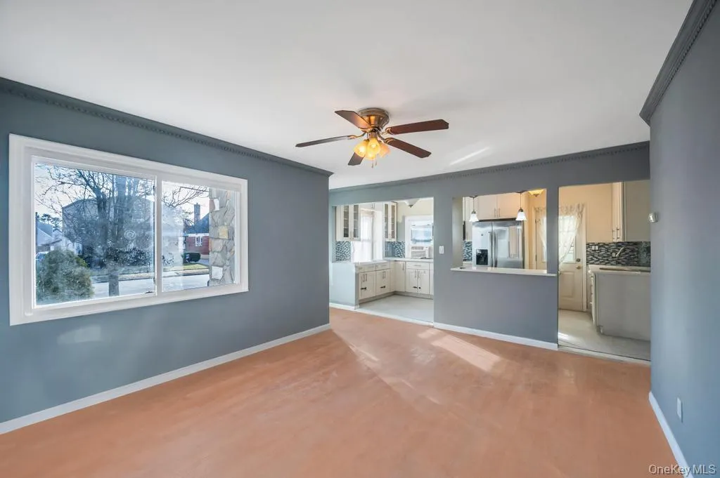 Unfurnished living room featuring a ceiling fan, crown molding, and light wood-type flooring Unfurnished living room featuring a ceiling fan, crown molding, and light wood-type flooring