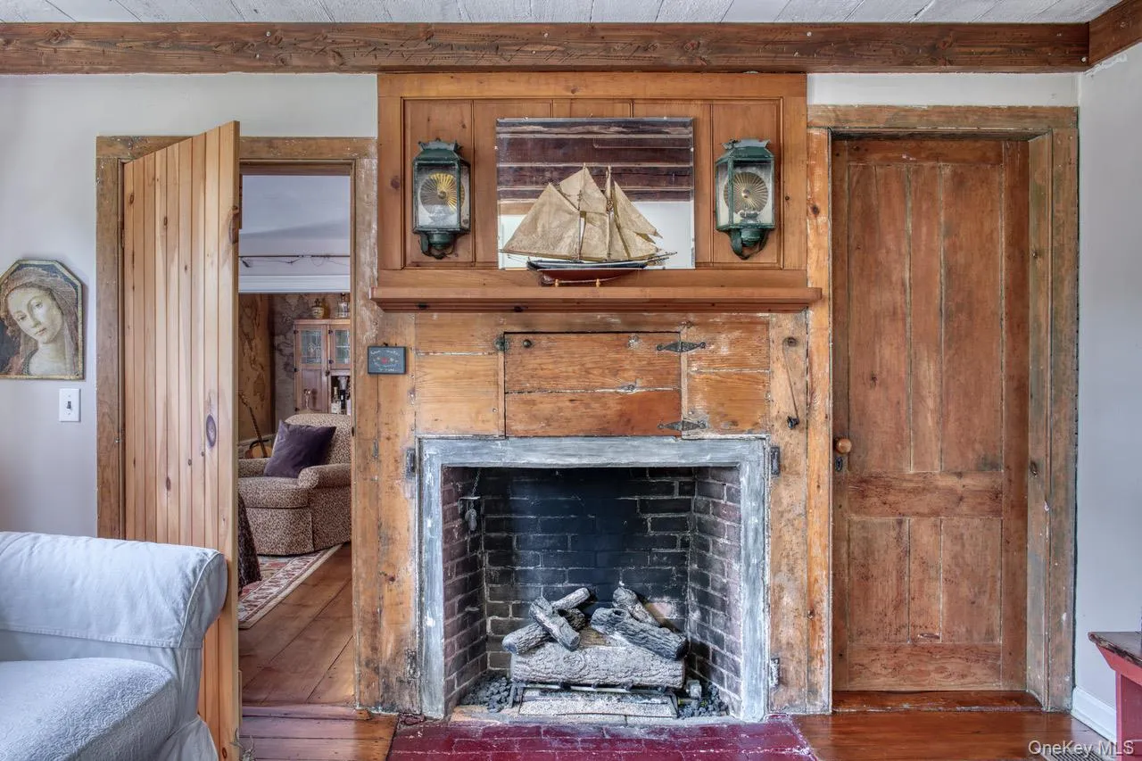 Detailed view of wood finished floors, beam ceiling, and a fireplace Detailed view of wood finished floors, beam ceiling, and a fireplace