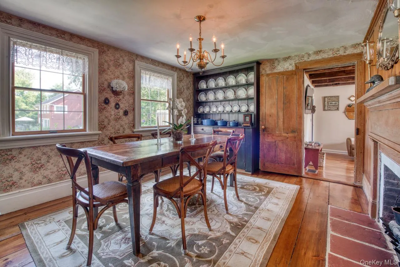 Dining area with wallpapered walls, light wood-type flooring, and a chandelier Dining area with wallpapered walls, light wood-type flooring, and a chandelier