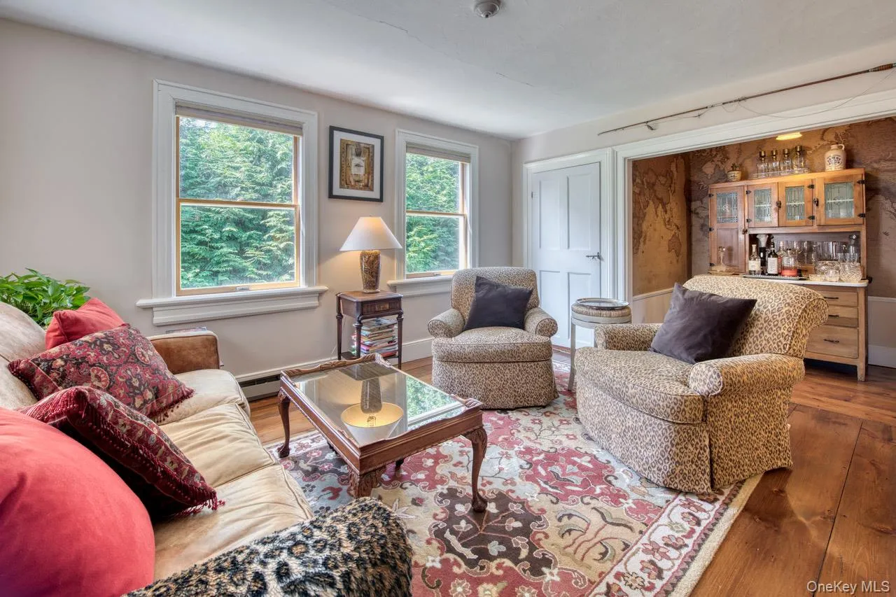 Living room featuring wood finished floors and a bar Living room featuring wood finished floors and a bar