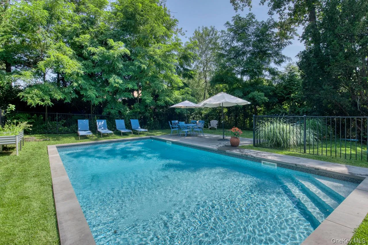 View of pool with a patio and view of scattered trees View of pool with a patio and view of scattered trees