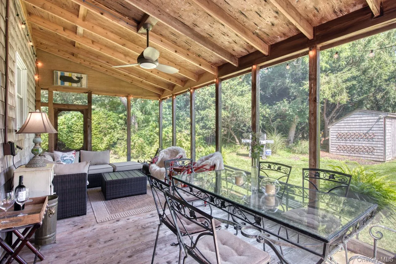 Sunroom with outdoor dining space, an outdoor hangout area, ceiling fan, and view of scattered trees Sunroom with outdoor dining space, an outdoor hangout area, ceiling fan, and view of scattered trees