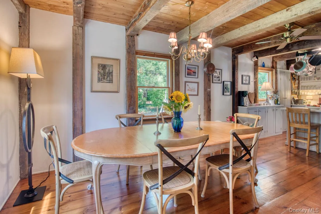 Dining room with a wood ceiling with exposed beams, hardwood / wood-style floors, ceiling fan, healthy amount of natural light, and a chandelier Dining room with a wood ceiling with exposed beams, hardwood / wood-style floors, ceiling fan, healthy amount of natural light, and a chandelier