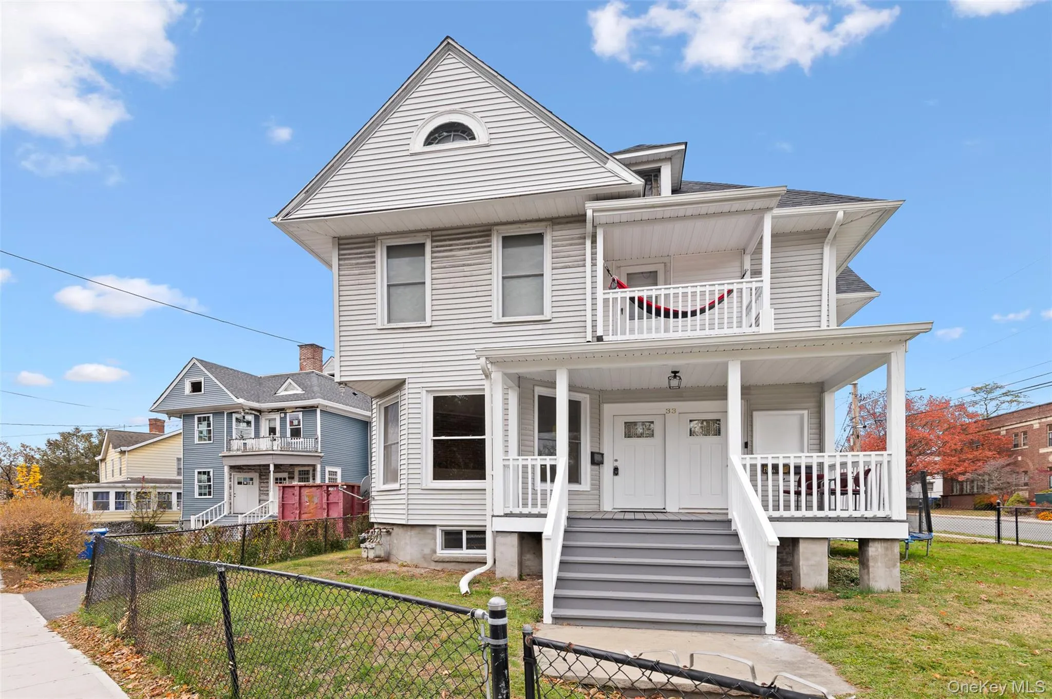 View of front of home with a fenced front yard, covered porch, a shingled roof, and a gate View of front of home with a fenced front yard, covered porch, a shingled roof, and a gate