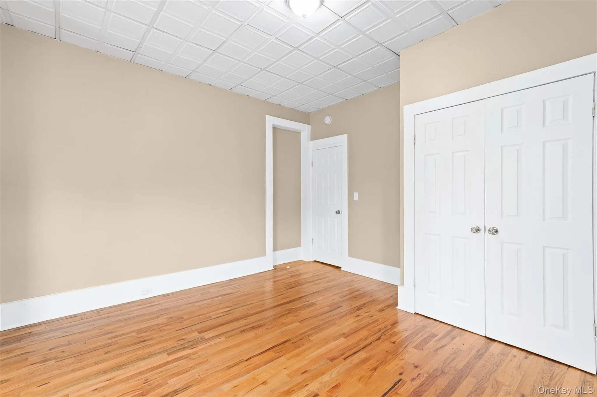 Unfurnished bedroom with light wood finished floors and a closet Unfurnished bedroom with light wood finished floors and a closet