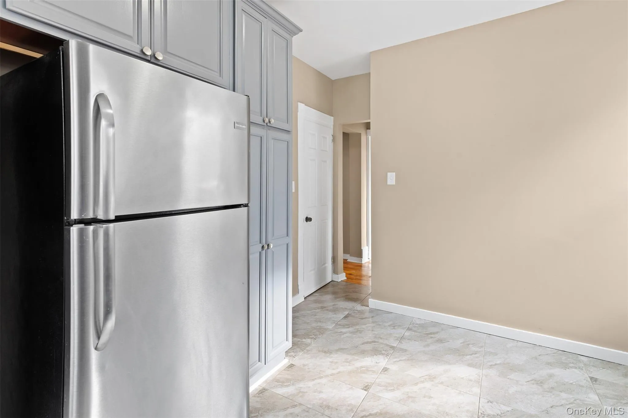 Kitchen with freestanding refrigerator and gray cabinetry Kitchen with freestanding refrigerator and gray cabinetry