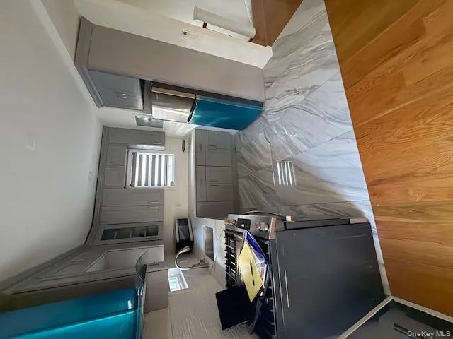 Kitchen with gray cabinetry, refrigerator, tasteful backsplash, glass insert cabinets, and plenty of natural light Kitchen with gray cabinetry, refrigerator, tasteful backsplash, glass insert cabinets, and plenty of natural light