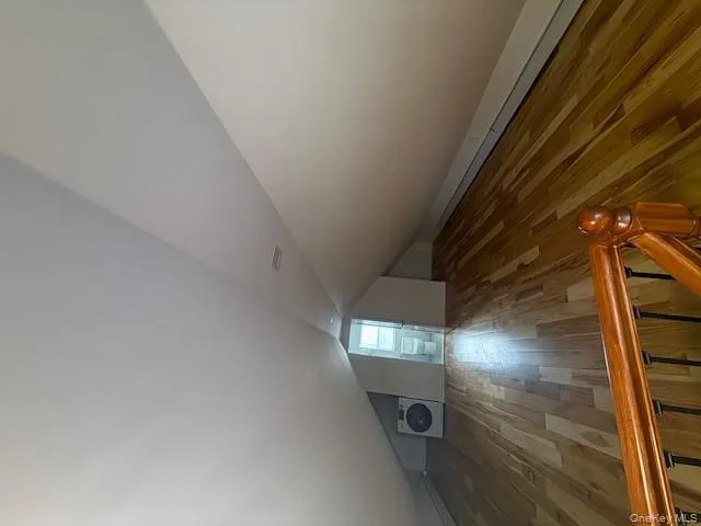 Additional living space featuring wood finished floors, washer / dryer, and lofted ceiling Additional living space featuring wood finished floors, washer / dryer, and lofted ceiling