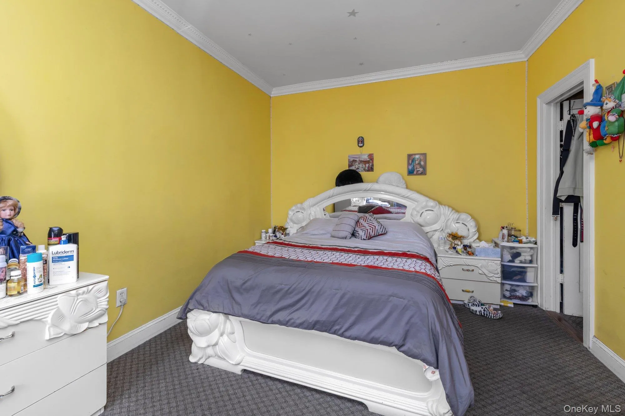 Carpeted bedroom with ornamental molding and baseboards Carpeted bedroom with ornamental molding and baseboards