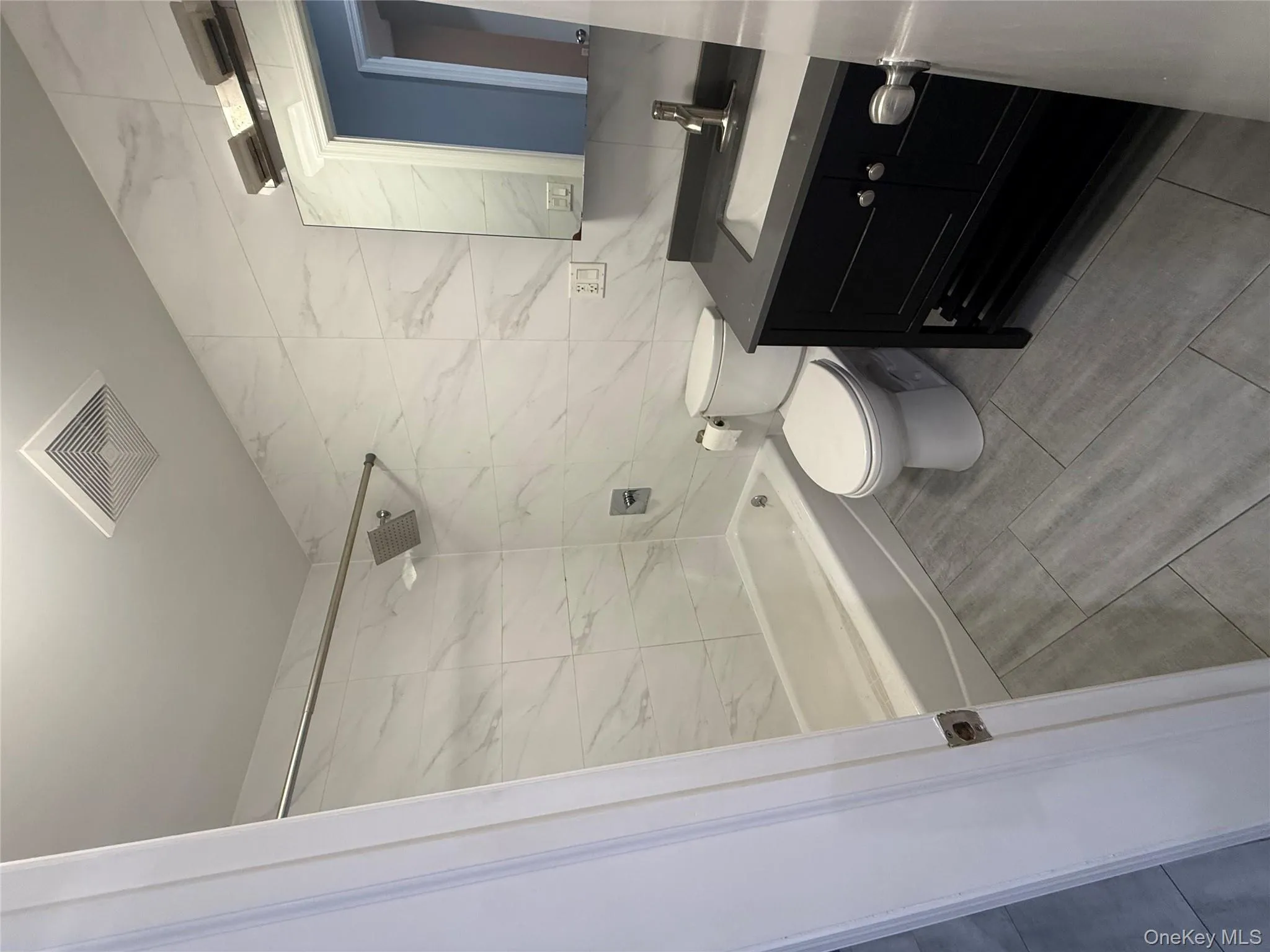 Full bathroom with tile walls, vanity, and tub / shower combination Full bathroom with tile walls, vanity, and tub / shower combination