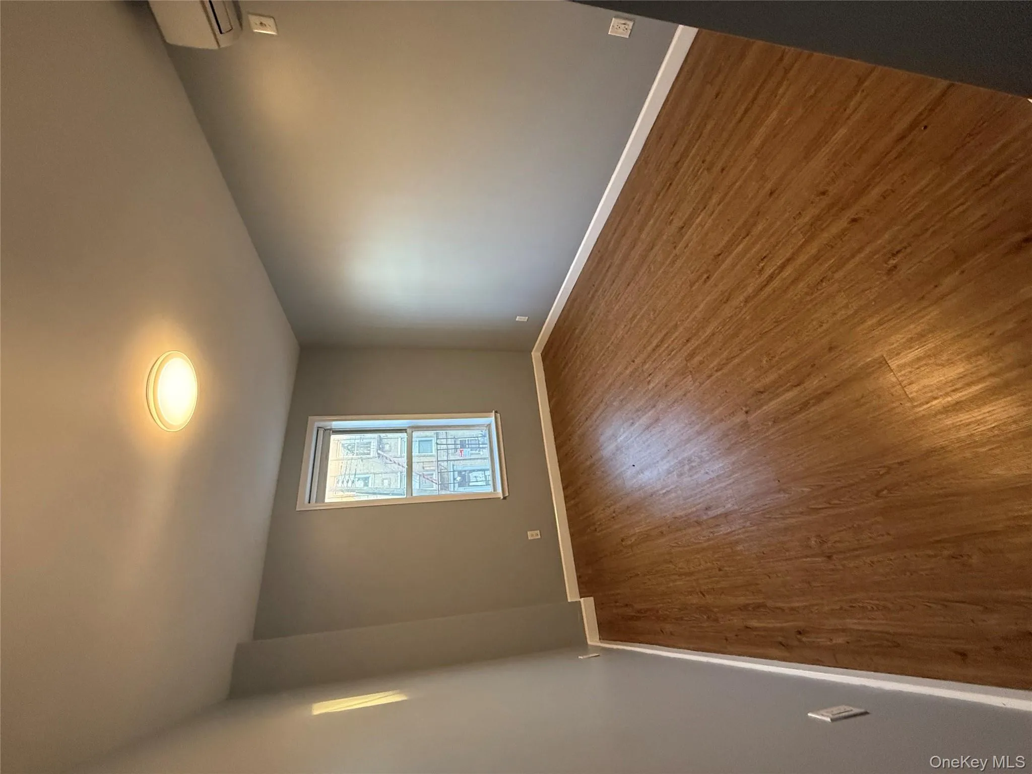 Unfurnished room featuring dark wood-type flooring and a wall mounted AC Unfurnished room featuring dark wood-type flooring and a wall mounted AC