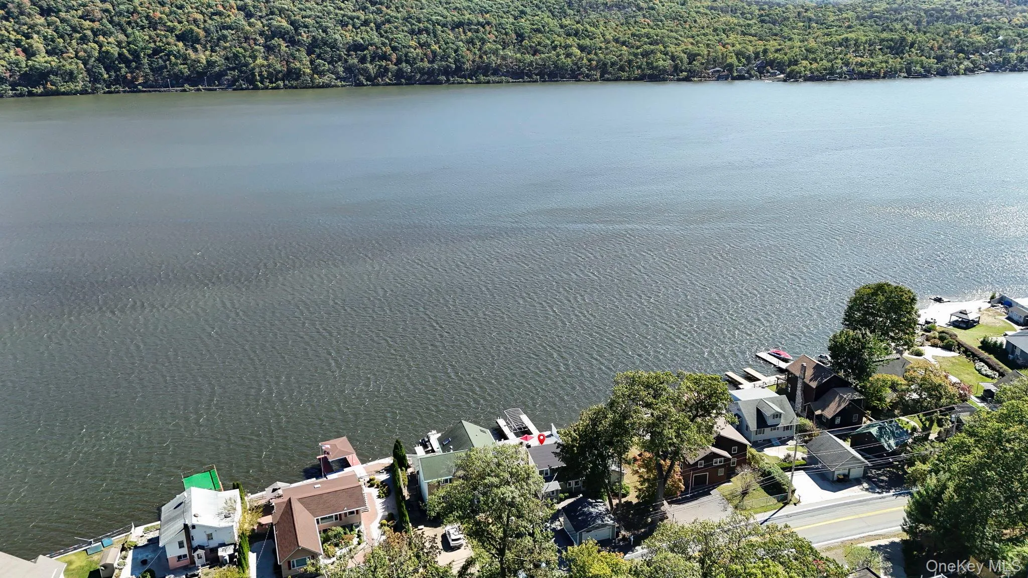 Aerial perspective of suburban area featuring a nearby body of water and a heavily wooded area Aerial perspective of suburban area featuring a nearby body of water and a heavily wooded area