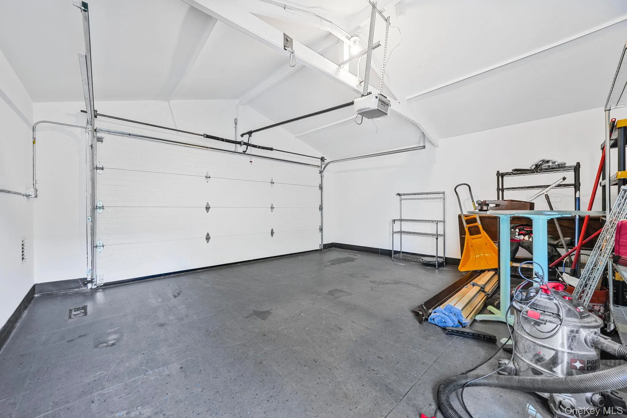 Garage featuring a garage door opener and baseboards Garage featuring a garage door opener and baseboards