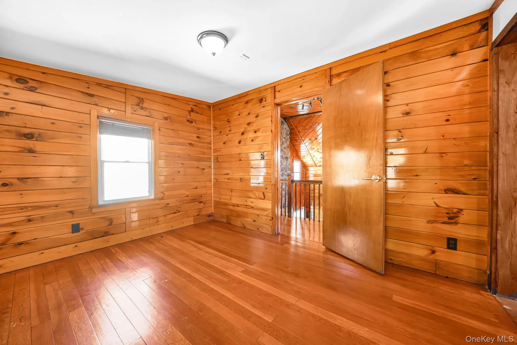 Empty room featuring wooden walls and wood-type flooring Empty room featuring wooden walls and wood-type flooring