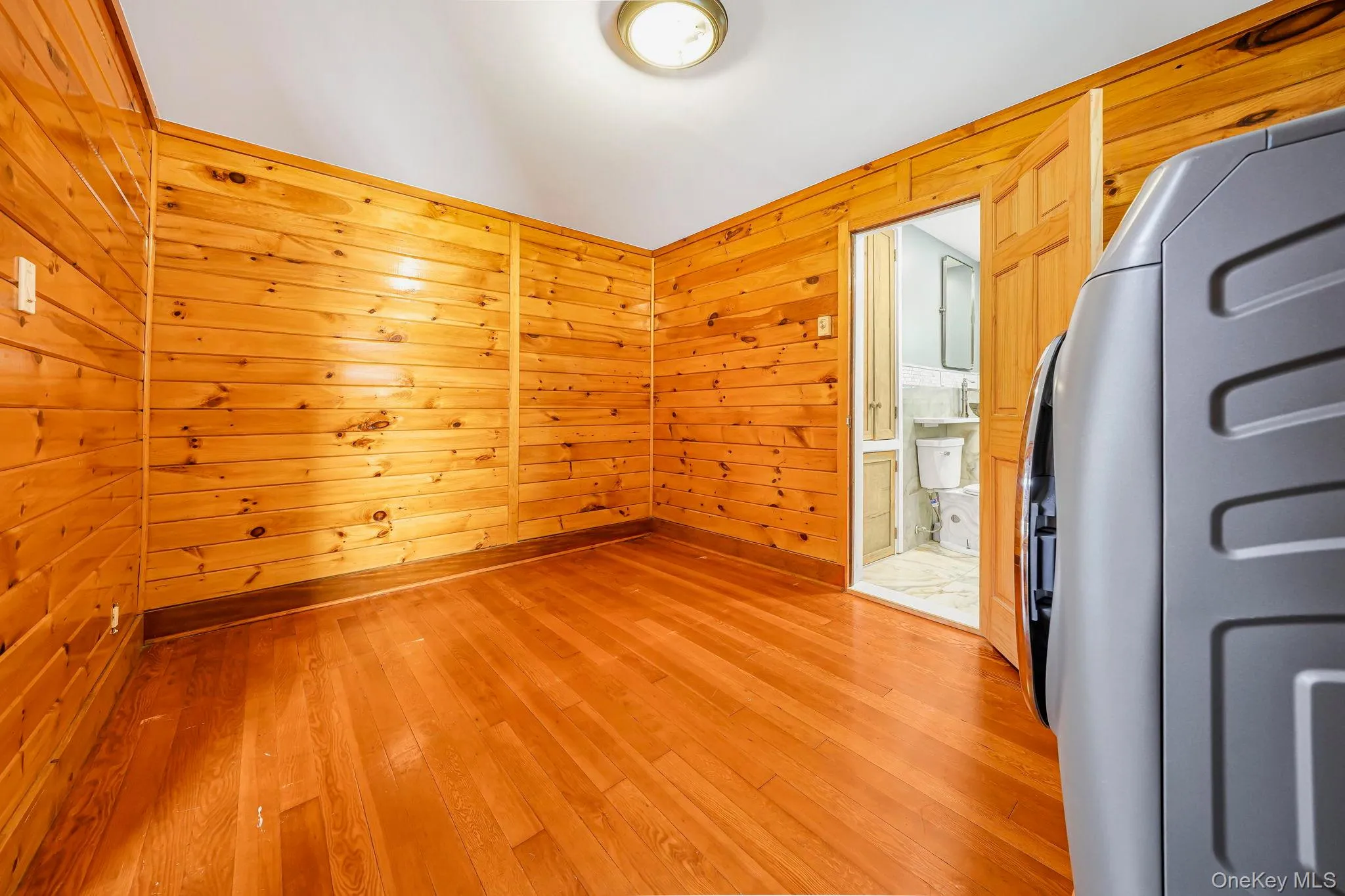 Spare room with wooden walls and light wood finished floors Spare room with wooden walls and light wood finished floors