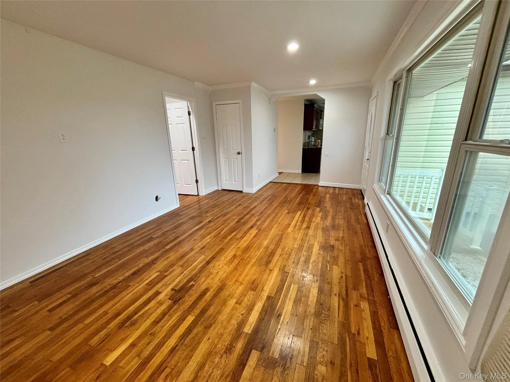 Spare room featuring a baseboard heating unit, hardwood / wood-style flooring, ornamental molding, and recessed lighting Spare room featuring a baseboard heating unit, hardwood / wood-style flooring, ornamental molding, and recessed lighting