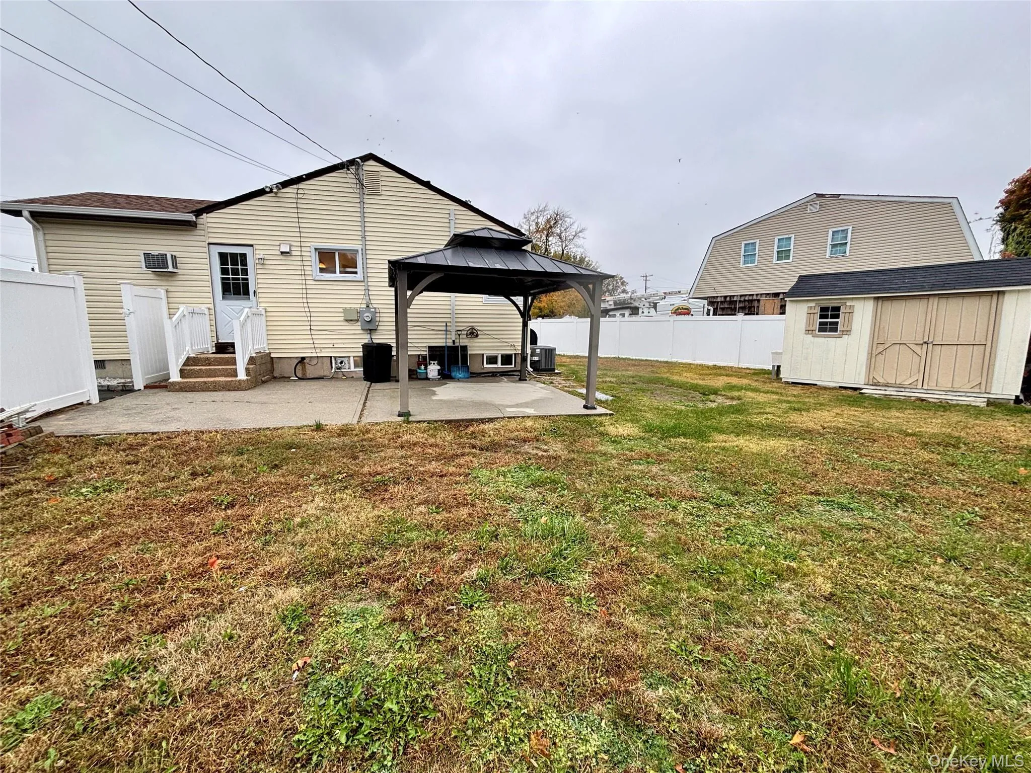 Rear view of house featuring a storage shed, a patio area, and a gazebo Rear view of house featuring a storage shed, a patio area, and a gazebo