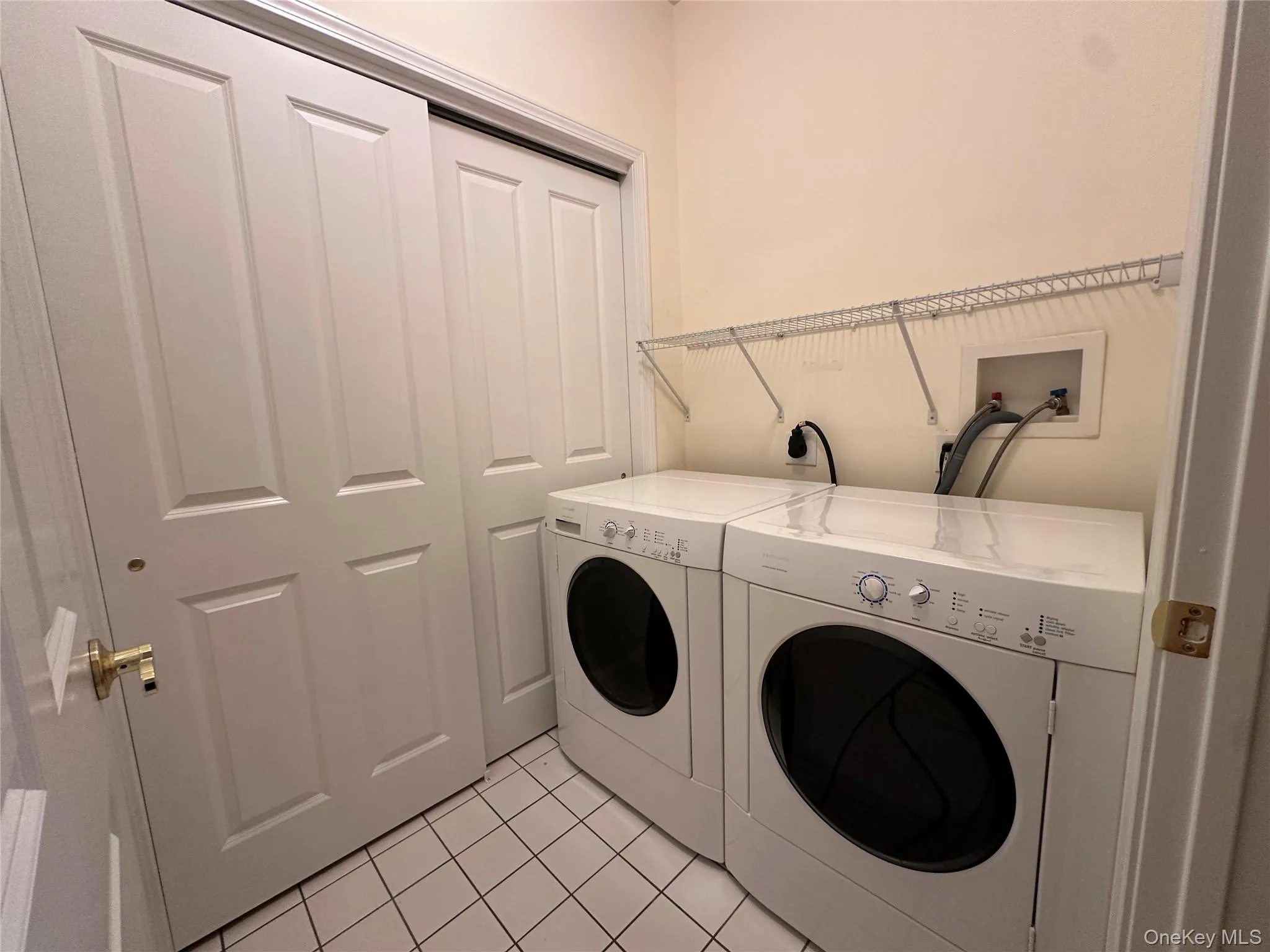 Washroom with light tile patterned floors and washer and dryer Washroom with light tile patterned floors and washer and dryer